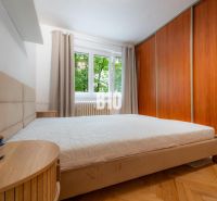 Schlafzimmer in einer 2-Zimmer-Wohnung mit Holzboden und Einbauschrank.