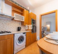 Küche mit Gasherd, Geschirrspüler und Bartisch in einer 2-Zimmer-Wohnung.