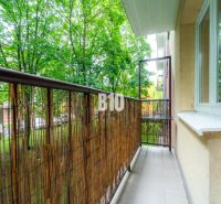 Ein Balkon in einer 2-Zimmer-Wohnung mit Blick ins Grüne, umgeben von Bäumen in der Stadt Martin.