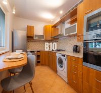 Küche in einer 2-Zimmer-Wohnung mit Holzelementen und Geräten.