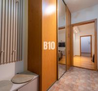 Eingangsflur mit Garderobe, Spiegelschrank und Holzboden in einer 2-Zimmer-Wohnung.
