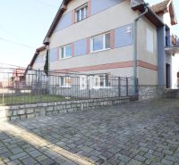 Ein Einfamilienhaus in Turany mit Hof und gepflasterter Zufahrtsstraße.
