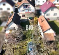 Ein Einfamilienhaus in Turany mit einem großen Hof und Anbauten, umgeben von einem Garten.