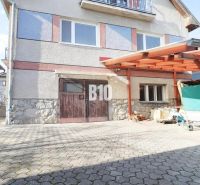 Ein Einfamilienhaus in Turany mit befestigter Zufahrtsfläche und einem Carport.