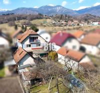 Ein Einfamilienhaus in Turany mit einem Schuppen, einem Garten und den umliegenden Bergen im Hintergrund.