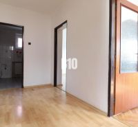 Flur mit Holzboden und Blick auf das Badezimmer in einem Einfamilienhaus.