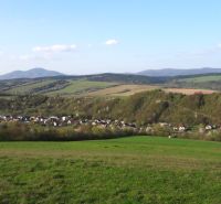 Ein Blick auf landwirtschaftliche und forstwirtschaftliche Flächen in Bogliarka mit hügeligem Horizont und Dorf.