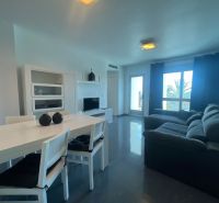 Esstisch mit Stühlen und Sofa, Ferienwohnung, Boden mit Holzdekor.