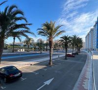 Palmen und entlang der Straße geparkte Autos bei den Apartments in La Manga del Mar Menor, Spanien.