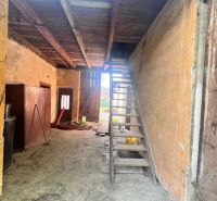 Lagerraum in einem Einfamilienhaus mit Holztreppe und Lehmboden.