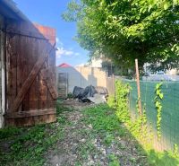 Der Garten des Einfamilienhauses in Brehoch, Nová Baňa, mit einem Holztor und einem Baum.