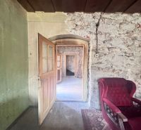 Steinwände mit rotem Sessel und offenen Türen in einem Einfamilienhaus.