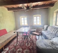 Wohnzimmer in einem Einfamilienhaus mit Holzdecke, Sofa und gemustertem Teppich.