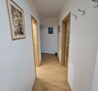 Ein Flur mit hellen Wänden und einem Boden in Holzoptik in einer 3-Zimmer-Wohnung.