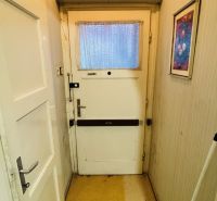 Eingangsflur in einer 3-Zimmer-Wohnung mit älteren Türen und hellen Wänden.