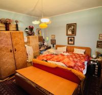 Ein Schlafzimmer in einer 3-Zimmer-Wohnung mit Vintage-Möbeln und Dekoration.