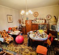 Ein Zimmer voller Vintage-Möbel und Dekorationen in einer 3-Zimmer-Wohnung mit Holzboden.