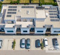 Das Gebäude in der Mesačná-Straße in Hviezdoslavov mit Solarpanelen und geparkten Autos.