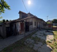 Einfamilienhaus in Nesvady mit beschädigtem Dach und sonnigem Hof.