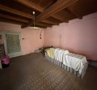 Ein Raum in einem Einfamilienhaus mit antiker Beleuchtung und einer Balkendecke.