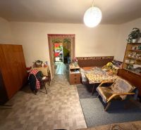 Wohnzimmer in einem Einfamilienhaus mit antiken Möbeln und Sesseln, Boden mit Holzdekor.