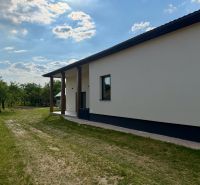 Das Äußere eines Einfamilienhauses in Zemplínska Široká, umgeben von Rasen und Bäumen.