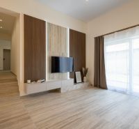 Wohnzimmer in einem Einfamilienhaus mit Holzboden und einem Fernseher an der Wand.