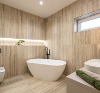 Badezimmer in einem Einfamilienhaus mit Holzboden, Badewanne und dekorativer Beleuchtung.