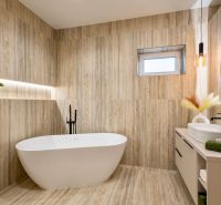 Badezimmer in einem Einfamilienhaus mit freistehender Badewanne, Holzdekor und Hängelampen.