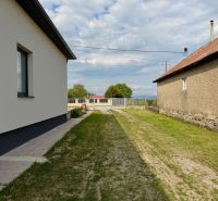 Ein Einfamilienhaus in Zemplínska Široká mit einem Rasen zwischen den Gebäuden und einem gepflegten Gehweg.