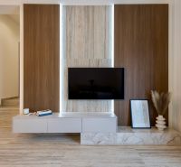 Innenraum eines Einfamilienhauses mit einer Wand in Holzoptik, einem Fernseher und Dekorationen.