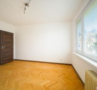 Ein Zimmer in einer 3-Zimmer-Wohnung mit einem Boden in Holzoptik und großen Fenstern.