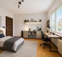 Schlafzimmer mit Bett, Schreibtisch und Boden in Holzoptik in einer 3-Zimmer-Wohnung.