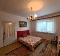 Schlafzimmer im Einfamilienhaus mit dekorativem Kronleuchter, Vorhängen und Teppich.