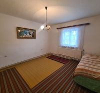 Innenraum eines Einfamilienhauses mit Bett, Bild und Fenster mit Vorhängen.