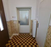 Fliesen mit Schachbrettmuster im Innenraum eines Einfamilienhauses mit weißen Wänden.