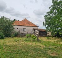 Ein Einfamilienhaus in Dulovce mit einem großen Hof und Garten, umgeben von Bäumen.