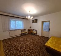 Wohnzimmer in einem Einfamilienhaus mit Teppich und gelbem Sofa.