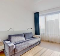 Helles Zimmer in einer 3-Zimmer-Wohnung mit Sofa, Tisch und Holzboden.