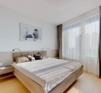 Schlafzimmer in einer 3-Zimmer-Wohnung mit Bett, Vorhängen und Boden in Holzoptik.