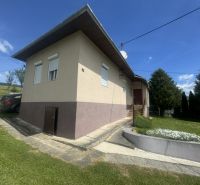 Ein Einfamilienhaus in Orlov mit Zufahrtsstraße, Auto und gepflegtem Garten.