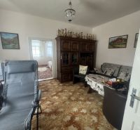 Ein Zimmer in einem Einfamilienhaus mit einem reich verzierten Schrank und bequemen Sitzgelegenheiten.