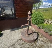 Ein Einfamilienhaus in Orlové mit einer alten Wasserpumpe auf einem Kiesuntergrund.