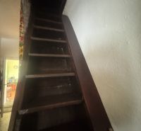 Eine Treppe, die in einem Einfamilienhaus nach oben führt, mit dunklen Holzstufen.