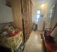 Der Flur in einem Einfamilienhaus mit bunten Vorhängen und Küchenmöbeln.