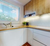 Helle Küche mit weißen Schränken und Holzelementen in einer 3-Zimmer-Wohnung.