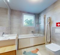 Badezimmer in einer 3-Zimmer-Wohnung mit gemusterten Fliesen, Badewanne und Fenster.