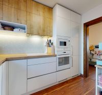 Küche in einer 3-Zimmer-Wohnung mit Holzboden und eingebauten Geräten.