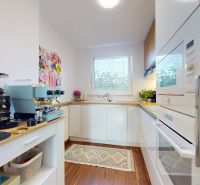 Küche in einer 3-Zimmer-Wohnung mit modernen Geräten und einem Boden in Holzoptik.
