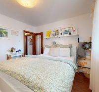 Helles Schlafzimmer mit Dekorationen und Holzboden in einer 3-Zimmer-Wohnung.